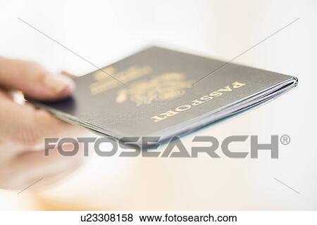 Stock Photo - Close up of woman's hand holding passport. Fotosearch
