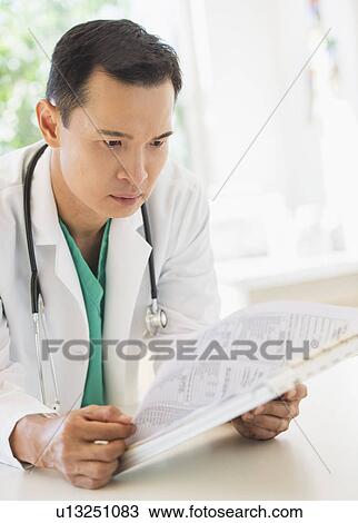 Doctor examining medical records View Large Photo Image Stock Image - Doctor examining medical records. Fotosearch