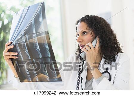 Doctor looking at MRI scan View Large Photo Image Stock Image - Doctor looking at MRI scan. Fotosearch