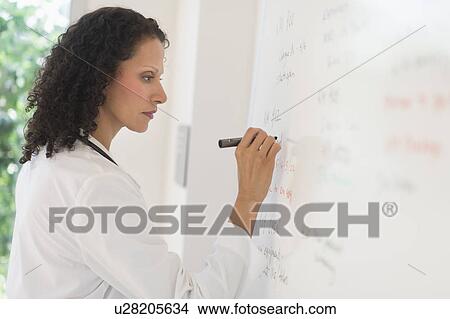 Picture - Doctor writing on whiteboard. Fotosearch