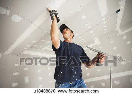 Drywall Worker Taping And Mudding Joint In Ceiling Stock Image Drywall Worker Taping And Mudding Joint