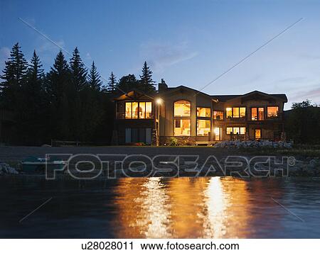 Stock Image - evening view of holiday villa from lake. Fotosearch