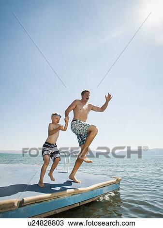 Father and son (4-5) jumping into lake caught View Large Photo Image Stock Image - Father and son (4-5) jumping into lake caught. Fotosearch