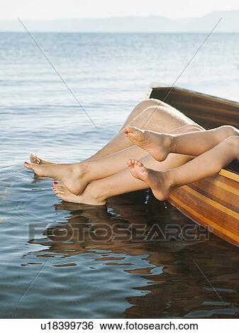 Feet of boy (4-5) and two adult people sticking out of boat View Large Photo Image Stock Photograph - Feet of boy (4-5) and two adult people sticking out of boat. Fotosearch