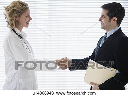 Stock Image - Female doctor greeting office worker. Fotosearch