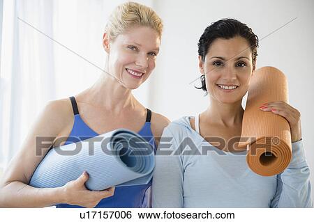 Stock Photograph - Female friends prepared for yoga class. Fotosearch