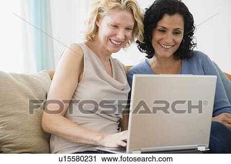 Female friends using laptop View Large Photo Image Stock Image - Female friends using laptop. Fotosearch