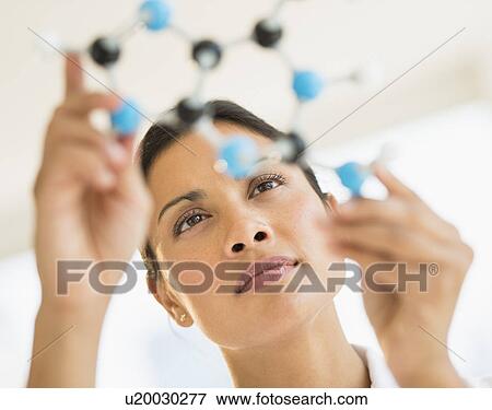 Stock Photo - Female scientist holding molecule model. Fotosearch