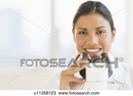 Female scientist looking through microscope View Large Photo Image Stock Image - Female scientist looking through microscope. Fotosearch