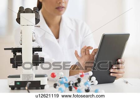 Stock Photo - Female scientist working on tablet PC . Fotosearch