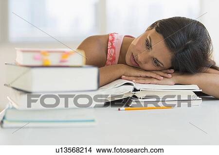 Picture - Female student leaning on books. Fotosearch