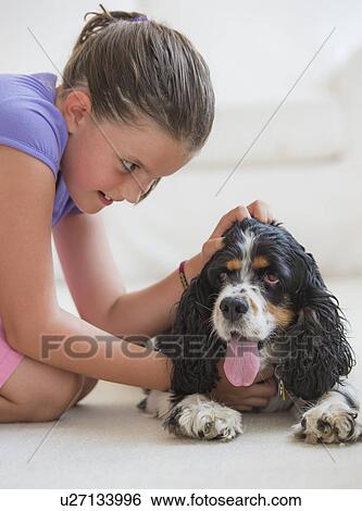 Girl (8-9) playing with her dog View Large Photo Image Stock Photograph - Girl (8-9) playing with her dog . Fotosearch