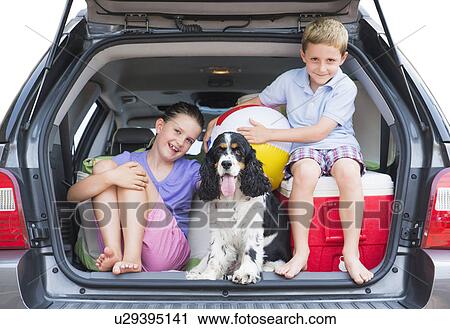 Stock Image - Girl (8-9) together with her brother (6-7) and their do setting out for vacations. Fotosearch