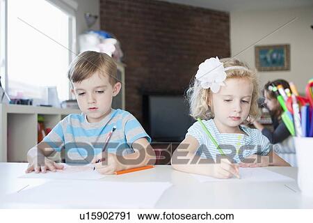 Stock Image - Girl and boy drawing in living room. Fotosearch
