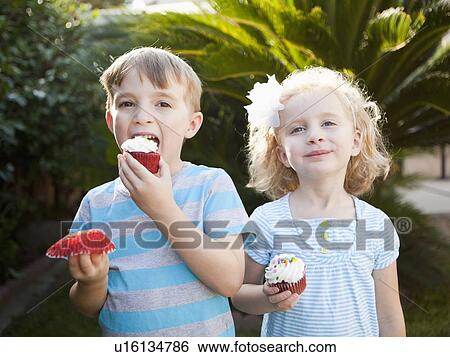 Girl and boy eating cupcakes View Large Photo Image Stock Photograph - Girl and boy eating cupcakes. Fotosearch