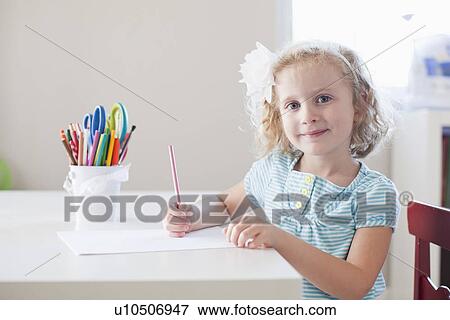 Girl sitting at table and looking at camera View Large Photo Image Stock Photo - Girl sitting at table and looking at camera. Fotosearch
