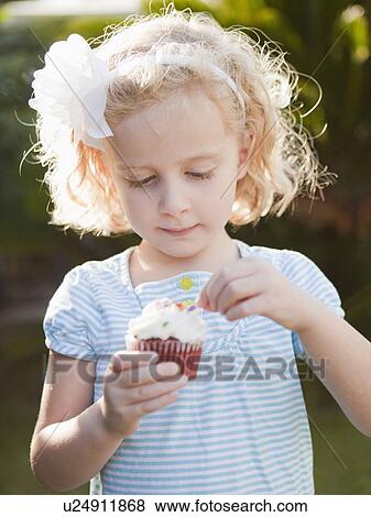 Stock Photo - Gril holding cupcake. Fotosearch