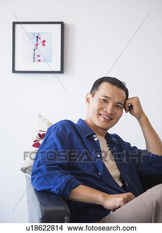 Happy mid adult man sitting in his armchair View Large Photo Image Picture - Happy mid adult man sitting in his armchair. Fotosearch
