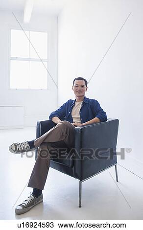 Happy mid adult man sitting in his armchair View Large Photo Image Stock Image - Happy mid adult man sitting in his armchair. Fotosearch