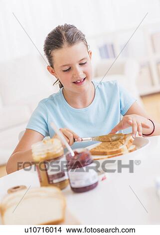 Happy young girl (8-9) having breakfast View Large Photo Image Picture - Happy young girl (8-9) having breakfast. Fotosearch