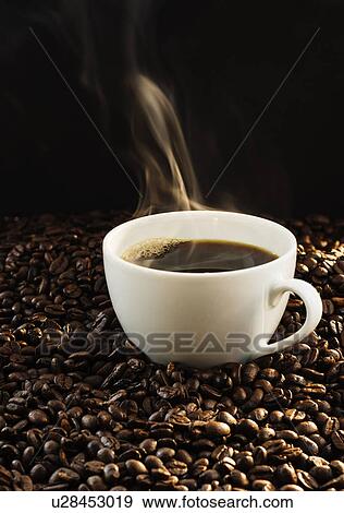 Stock Photo - Hot coffee and coffee beans, studio shot. Fotosearch