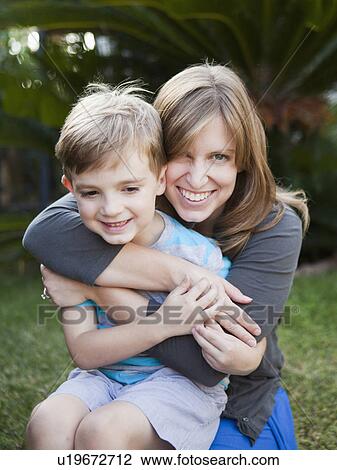Stock Image - Laughing mother hugging her son. Fotosearch