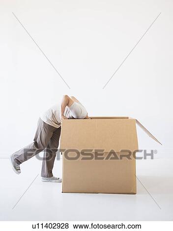 Man hiding inside cardboard box View Large Photo Image Stock Photo - Man hiding inside cardboard box. Fotosearch
