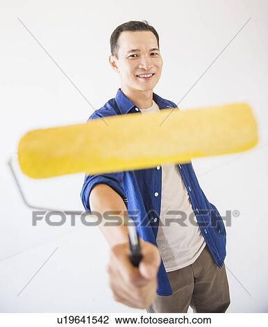 Man holding painting roll View Large Photo Image Stock Image - Man holding painting roll. Fotosearch