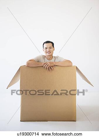 Picture - Man sitting in cardboard box. Fotosearch