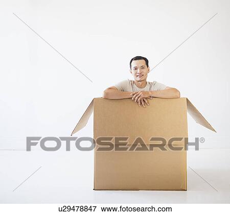 Man sitting in cardboard box View Large Photo Image Stock Photo - Man sitting in cardboard box. Fotosearch