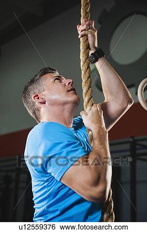 Mature man climbing up rope View Large Photo Image Stock Photograph - Mature man climbing up rope. Fotosearch