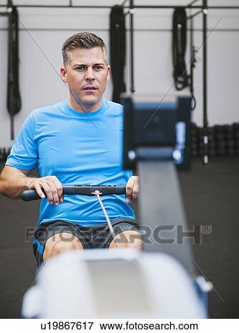 Mature man exercising on row machine in gym View Large Photo Image Stock Photo - Mature man exercising on row machine in gym. Fotosearch