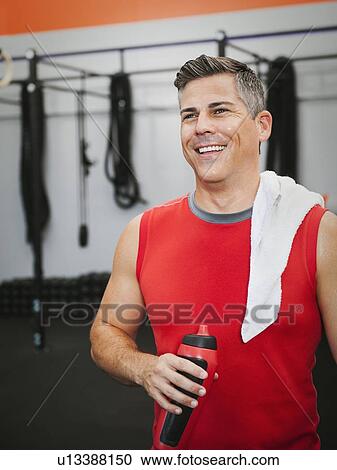 Stock Image - Mature man taking break from exercising. Fotosearch