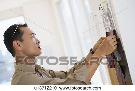 Stock Image - Mid adult fashion designer at work. Fotosearch