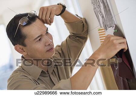 Mid adult fashion designer at work View Large Photo Image Stock Photograph - Mid adult fashion designer at work. Fotosearch
