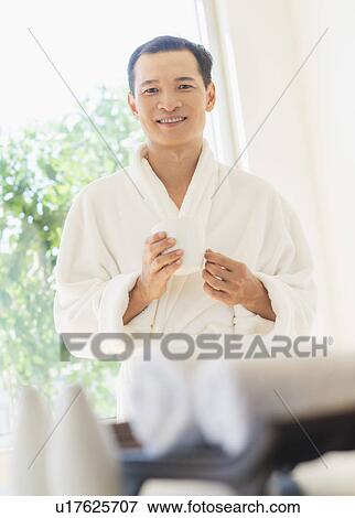 Stock Photo - Mid adult man holding cup of healthy herbal tea. Fotosearch