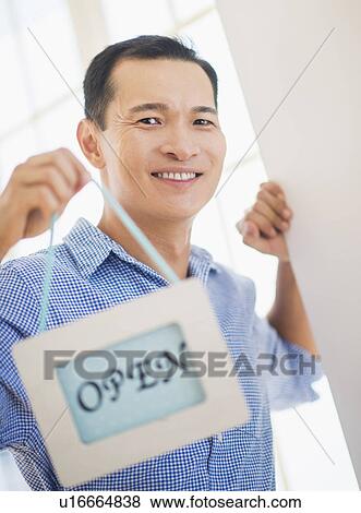 Mid adult man holding open sign View Large Photo Image Stock Photo - Mid adult man holding open sign. Fotosearch