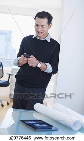 Mid adult man text messaging View Large Photo Image Stock Photograph - Mid adult man text messaging. Fotosearch