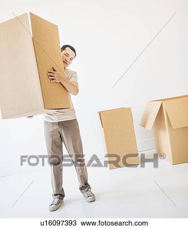 Mid adult moving cardboard boxes View Large Photo Image Stock Image - Mid adult moving cardboard boxes. Fotosearch