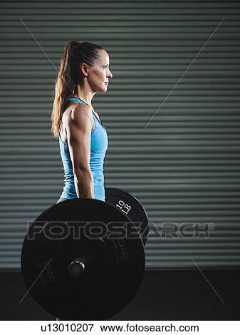 mid adult woman lifting barbell View Large Photo Image Stock Photo - mid adult woman lifting barbell . Fotosearch