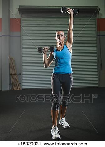 Mid adult woman lifting free weights View Large Photo Image Stock Image - Mid adult woman lifting free weights. Fotosearch