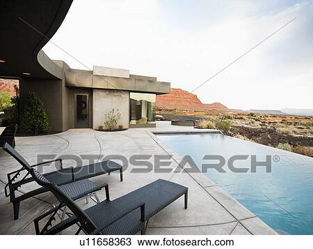Stock Image - Modern luxury home facing swimming pool. Fotosearch