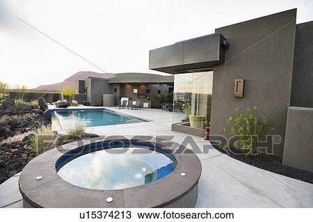 Stock Image - Modern luxury home facing swimming pool. Fotosearch