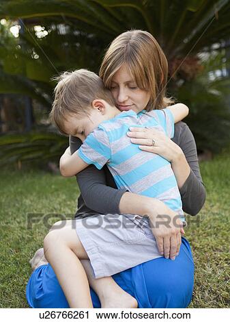Stock Image - Mother hugging her son. Fotosearch