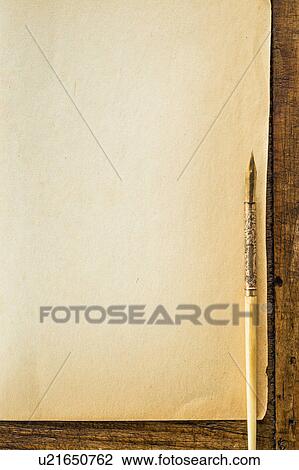 Stock Image - Old brown paper with fountain pen, studio shot. Fotosearch