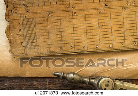 Stock Image - Old brown paper with ruler and compass, studio shot. Fotosearch