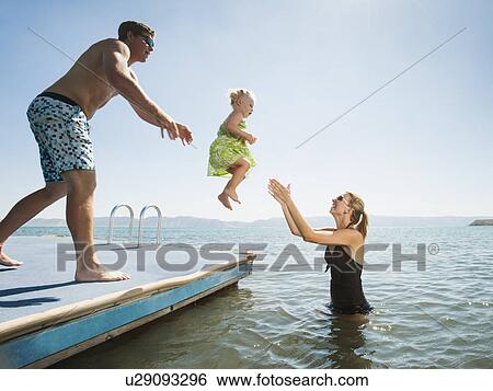 Parents playing with their daughter (2-3) in lake View Large Photo Image Stock Photograph - Parents playing with their daughter (2-3) in lake. Fotosearch
