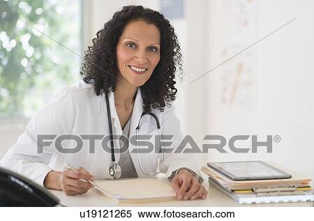 Portrait of doctor sitting in office View Large Photo Image Stock Photography - Portrait of doctor sitting in office. Fotosearch