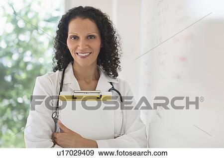 Stock Photo - Portrait of doctor standing in office. Fotosearch