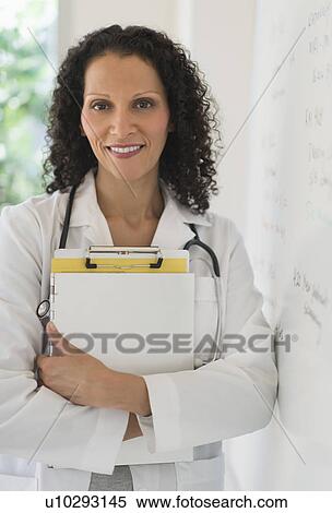 Portrait of doctor standing in office View Large Photo Image Stock Photography - Portrait of doctor standing in office. Fotosearch